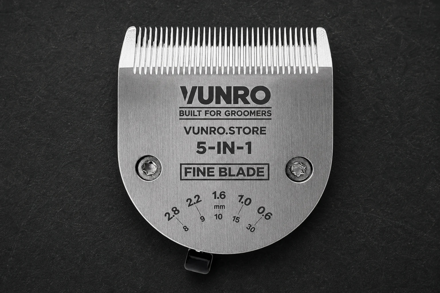Adjustable Ceramic 5 in 1 Fine Dog Clipper Blade (0.6 mm - 2.8 mm) on a dark grooming workbench