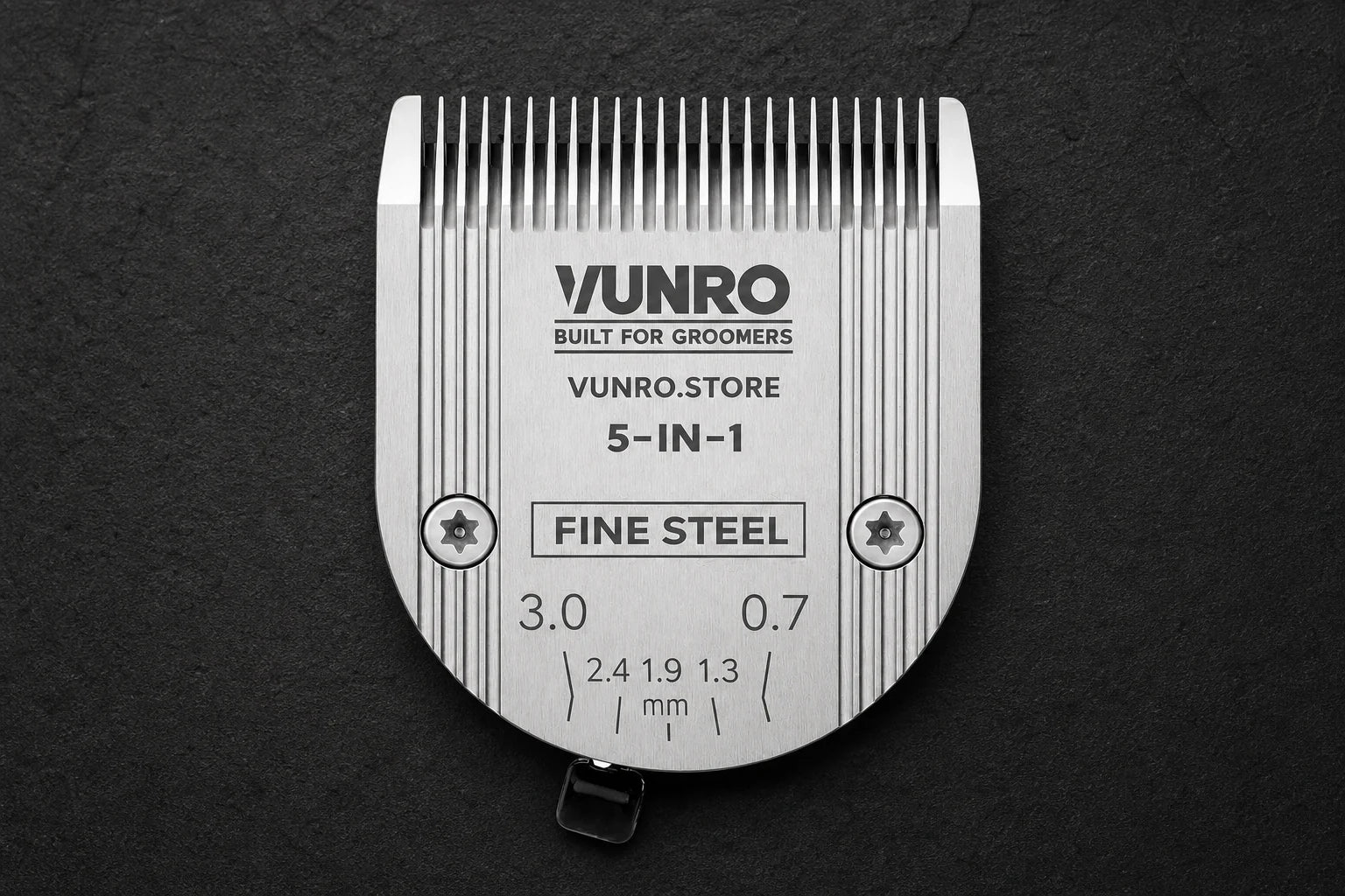 Adjustable Steel 5 in 1 Fine Dog Clipper Blade (0.7 mm - 3 mm) on a dark grooming workbench